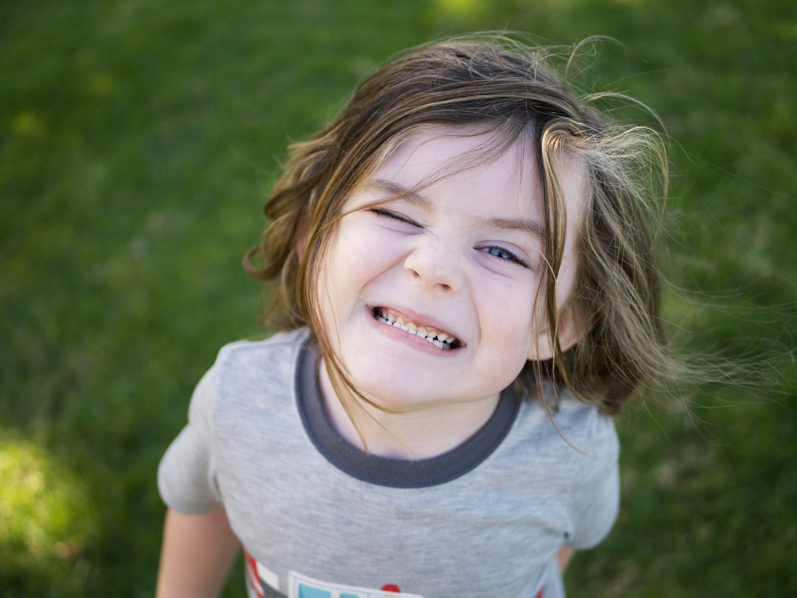 Young girl laughing outside.